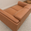 A close-up of a Hugo vegan suede two-seater sofa upholstered in warm tan leather or faux leather, shown in a styled interior setting with a textured rug and white paneled wall.