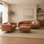 Hugo Vegan suede 3 seater and 2 seater with ottoman lounge suite on a beige woven rug in a warm, minimalist interior.